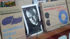 Fotografie Milana Kundery mezi jeho knihami v pražském knihkupectví