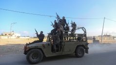 Palestinští ozbrojenci jedou na izraelském vojenském vozidle, kterého se zmocnili v oblastí jižního Izraele