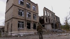 Ukrajinský policista před zničeným domem v Avdijivce