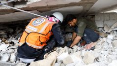 Záchranář a Palestinec prohledávají trosky