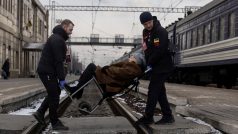 Dobrovolníci nevládní organizace Východ SOS pomáhají ženě nastoupit do evakuačního vlaku v ukrajinském Pokrovsku po zesílení ruských raketových úderů v okolí Avdijivky