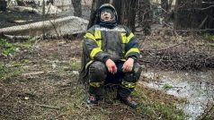 Zraněný záchranář sedí pod stromem v dějišti ruského raketového útoku
