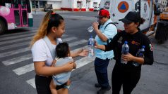 Mexická policistka rozdává lahve s vodou, 9. května 2024