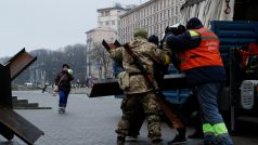 Vojáci a dobrovolníci umisťují protitankové zátarasy na check-pointu v centru Kyjeva