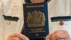 Britská ministryně vnitra Priti Patelová drží nový modrý pas.