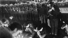 Studenti zapalují svíčky před policejním kordonem, který zastavil jejich pokojný protestní pochod na Národní třídě. Při policejním zásahu bylo zraněno přes 560 mladých lidí. (zakoupeno z ČTK)
