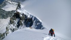 Švýcarsko, srpen 2023: Dlouhý firnový hřeben před námi se táhne až k vrcholu, stoupá do nebe, do mraků, vrchol ještě není vidět