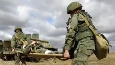Ruští vojáci na frontě odnášejí zraněného kolegu