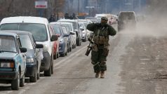 Příslušník proruských jednotek prochází podél řady aut s evakuovanými, kteří opouštějí obležené jihoukrajinské přístavní město Mariupol
