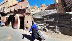 Žena prochází před zničeným domem v Marrákeši