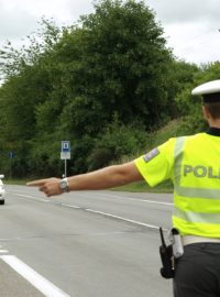 Policista vybírá auto ke kontrole