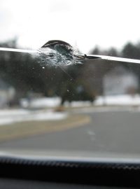 Prasklé čelní sklo vozu po nárazu kamínku (ilustrační foto)