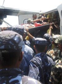 Záchranáři vynášejí zraněné z letadla, které havarovalo na horském letišti v Nepálu