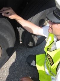 Dálniční policista Roman Hlouch kontroluje pneumatiky u kamionu