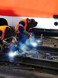 Dělníci pracují na opravě kolejí