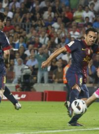 Barcelona&#039;s Xavi Hernandez (C) fights for the ball against Granada&#039;s goalkeeper Tono Martinez (R) after a Lionel Messi (L) shot during their Spanish First Division soccer league match at Camp Nou stadium in Barcelona  September 22, 2012
