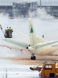 Technici na mnichovském letišti ošetřují před startem letadlo odmrazovací směsí