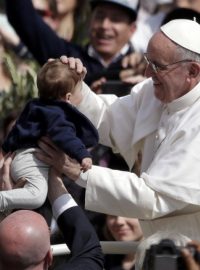 Papež František žehná dítěti během mše o Květné neděli na Svatopeterském náměstí.
