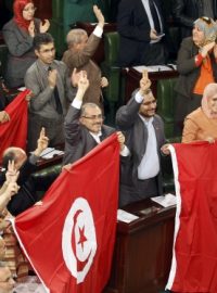 Zákonodárci v tuniském parlamentu se radují se schválení nové ústavy. 27. 1. 2014