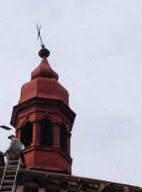 Dělníci v Litohoři opravují nakloněný kříž na kostele