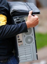 Německý policista odnáší počítač zabavený při razii v Berlíně. Policie hledala důkazy o verbování bojovníků do Sýrie