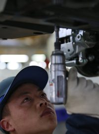Čínká ekonomika zpomaluje. Na ilustračním snímku montuje dělník elektroniku na výrobní lince automobilky