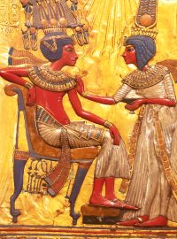 Faraon Tutanchamon ve výjevu na opěrce křesla