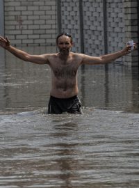 Obyvatel Chersonu se brodí zatopenou ulicí poté, co výbuch zničil hráz nádrže Nová Kachovka.