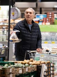 Muž váží brambory v obchodě