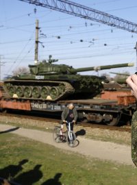 Ruský důstojník fotí vlak s vojenskou technikou