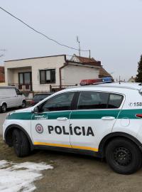 Policista se služebním psem před domem, kde Ján Kuciak a jeho snoubenka Martina Kušnírová žili a byli zavražděni (Veľká Mača, 27. února 2017).