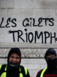 Žluté vesty zvítězí - jeden z nápisů, kterými protestující a vandalové poškodili fasádu pařížského Vítězného oblouku