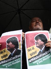 Muž s plakáty během demonstrace na podporu bolivijského exprezidenta Moralese před bolivijskou ambasádou v Mexiku