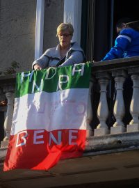 Žena vyvěsila na balkon vlajku s nápisem, že zase bude dobře.