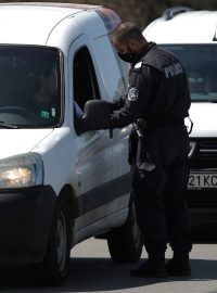 Bulharští policisté kontrolují dokldy řidičů opouštějící Sofii po jejím uzavření kvůli koronaviru