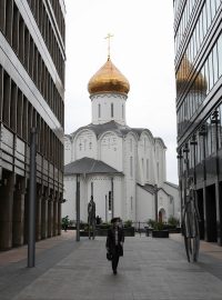 Žena s rouškou prochází obchodní čtvrtí v Moskvě