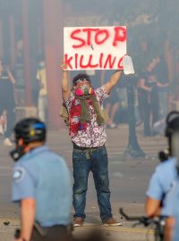 „Zastavte vraždění,“ uvádí nápis na ceduli maskovaného demonstranta před policejní stanicí v Minneapolisu