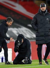 Klečící Ralph Hasenhüttl emotivně slaví se svým asistentem vítězství nad Liverpoolem Jürgena Kloppa (vpravo)