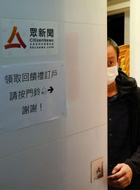Zaměstnanec hongkongského nezávislého zpravodajského portálu Citizen News vykukuje z kanceláře