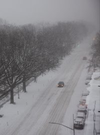 Auta jezdí po zasněžené Central Park West avenue v New Yorku poté, co oblast zasáhla silná sněhová bouře