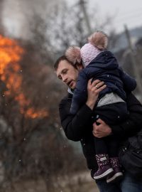Muž s dítětem po těžkém ostřelování unikají z města Irpiň po jediné únikové cestě používané místními obyvateli, zatímco ruské jednotky postupují směrem k hlavnímu městu Kyjev