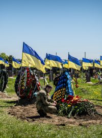 Ukrajinský voják u hrobu kamaráda na hřbitově v Dnipru