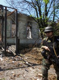 Policista kontroluje oblast během evakuace obyvatel při ruském ostřelování obce Novomychajlivka v Doněcké oblasti