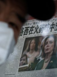 Muž v Pekingu u novinového stánku, ve kterém noviny informují o cestě americké předsedkyně sněmovny Nancy Pelosiové