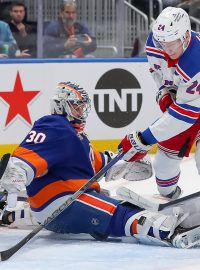 Brankář New York Islanders Ilja Sorokin zasahuje proti Kaapovi Kakkovi z New York Rangers během první třetiny.