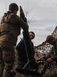 Příslušníci ukrajinské armády nabíjejí granát do minometu před střelbou na ruské vojáky u Bachmutu