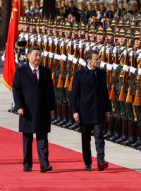 Čínský prezident Si Ťin-pching a francouzský prezident Emmanuel Macron hodnotí vojáky během oficiálního ceremoniálu ve Velké síni lidu