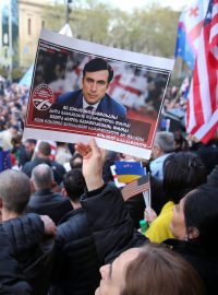 Účastnice demonstrace drží plakát vězněného exprezidenta Michaila Saakašviliho