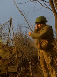 Ukrajinský voják při střelbě na ruské jednotky u frontové linie u Bachmutu