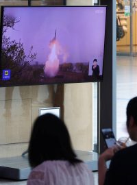 Cestující na nádraží sledují zprávy o tom, že Severní Korea odpálila balistickou raketu dlouhého doletu